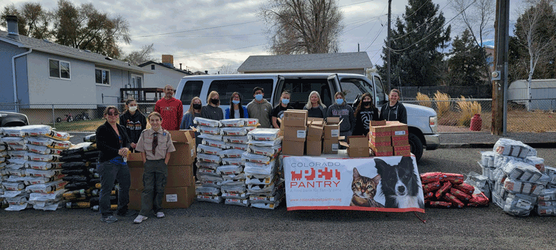 Volunteers pose with donations of pet supplies.
