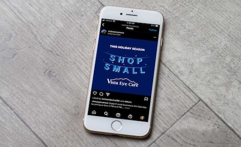 Shop Small graphic depicted on cell phone sitting on wooden surface