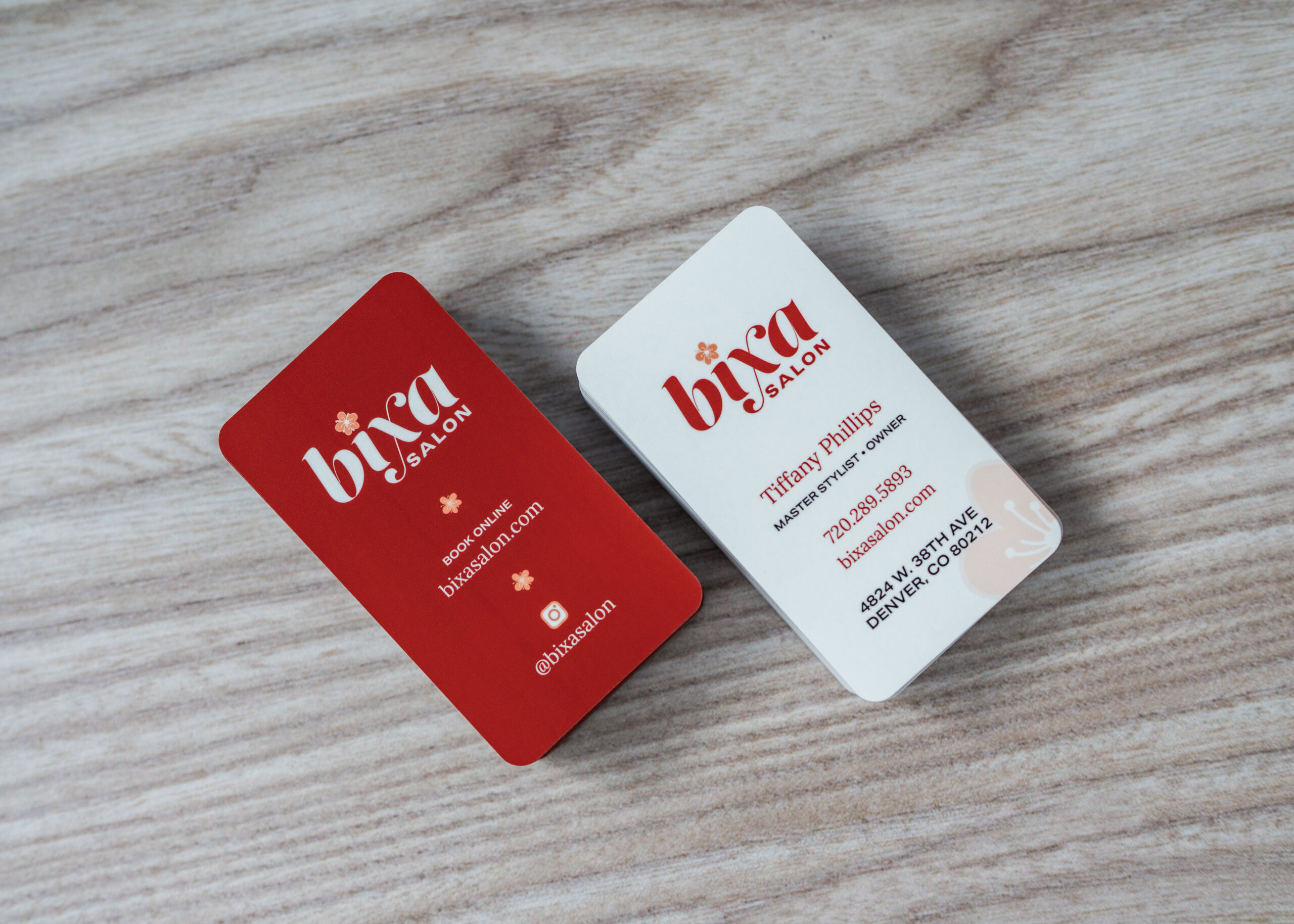 Red and white corner-rounded business cards on wood grain background