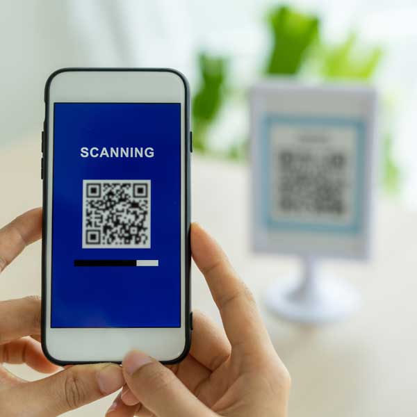 Hands holding a phone while scanning a QR code.
